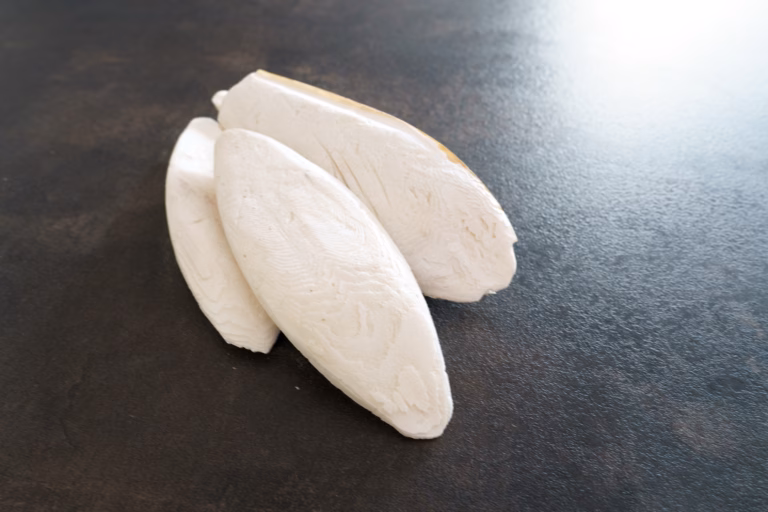 Drei Sepiaschalen für Wellensittiche liegen auf einem Tisch.